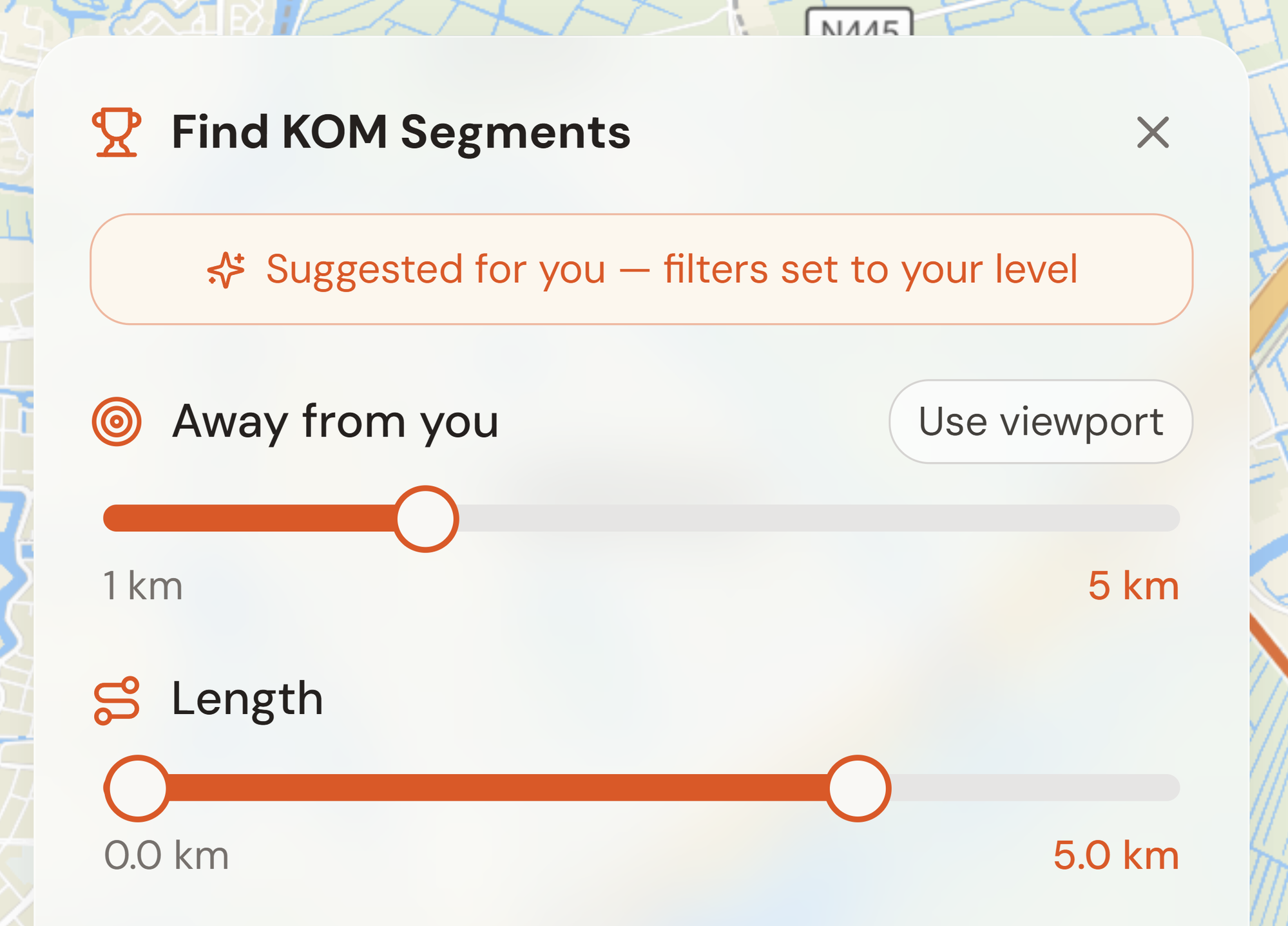 The Find KOM Segments panel on the map, with a 'Suggested for you — filters set to your level' button above the search-radius and length sliders.